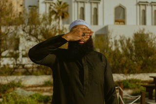 Man in een zwarte qamis voor de moskee bij Europa Point in Gibraltar