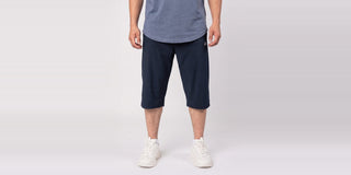 Man in een navy awrah short tot voorbij de knie met een ruim T-shirt