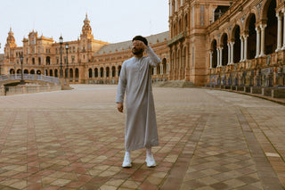 Man in een lichtgrijze qamis op het grote plein van de Plaza de España in Sevilla