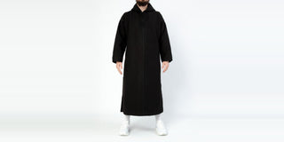Man in een zwarte djellaba met capuchon