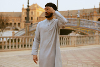 Man in een lichtgrijze qamis met knoopsluiting op de Plaza de España in Sevilla